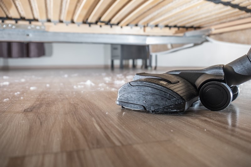 hoovering dust off wooden floor