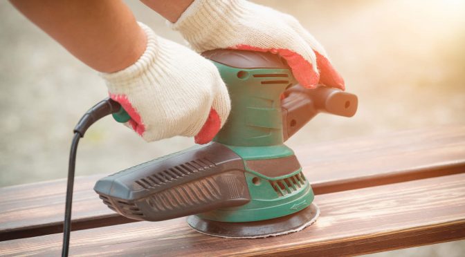 Sanding a wood with orbital sander