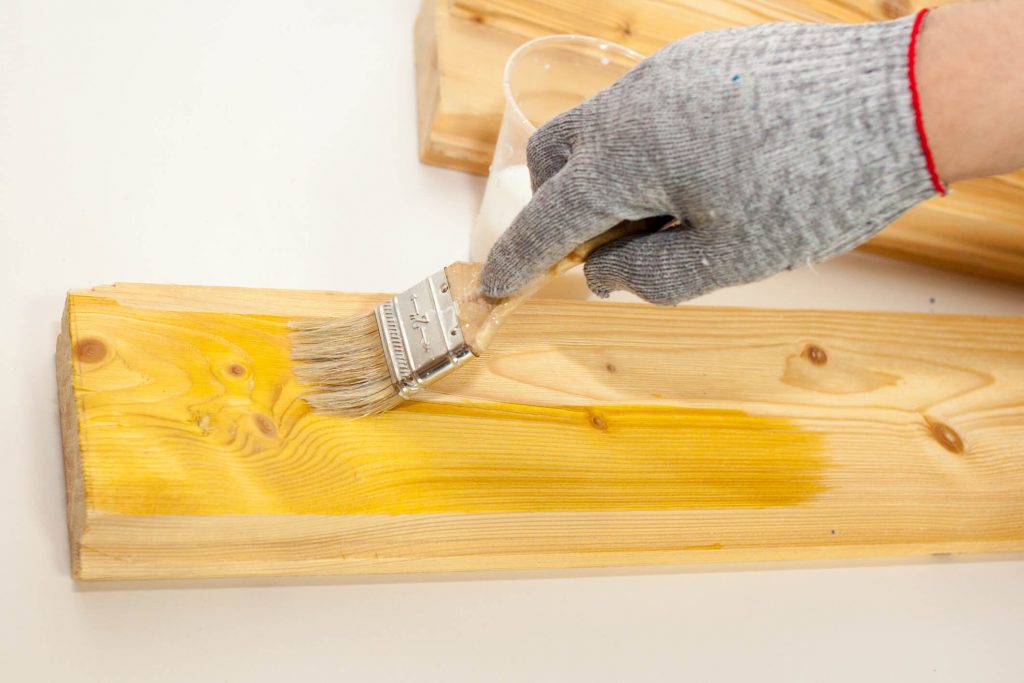 Applying primer on wood.