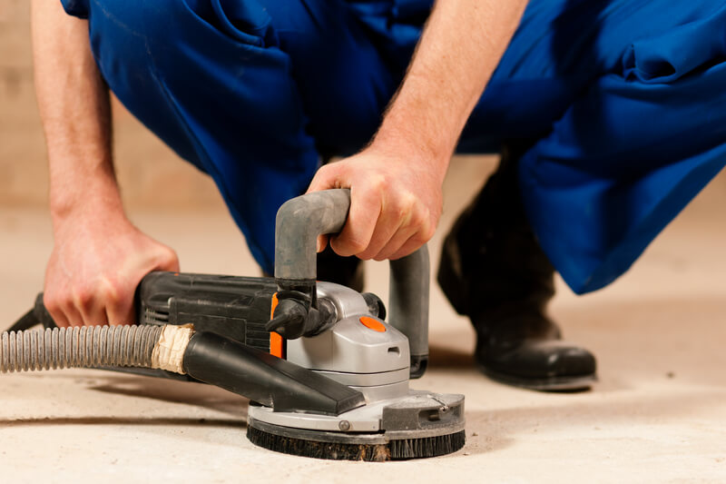 Manually sanding floor with floor sander